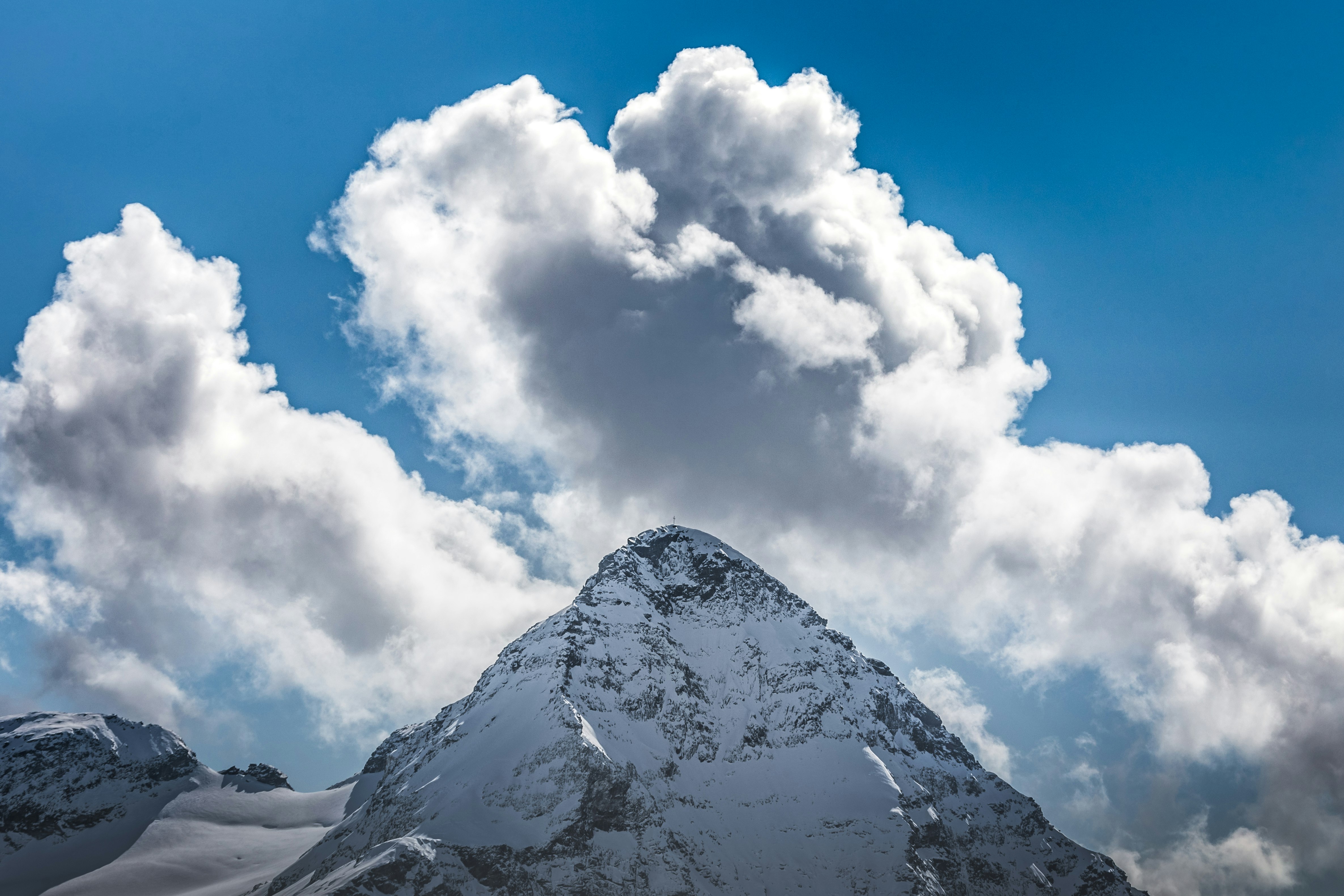 white clouds over snow covered mountain